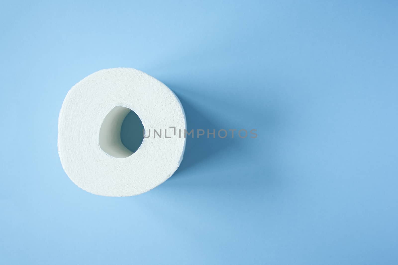 Toilet paper roll on a blue background top view. Toilet paper purchase due to kronavirus concept. Personal hygiene and stopping the spread of the virus. Cleanliness, Hygiene, Sterility copy space