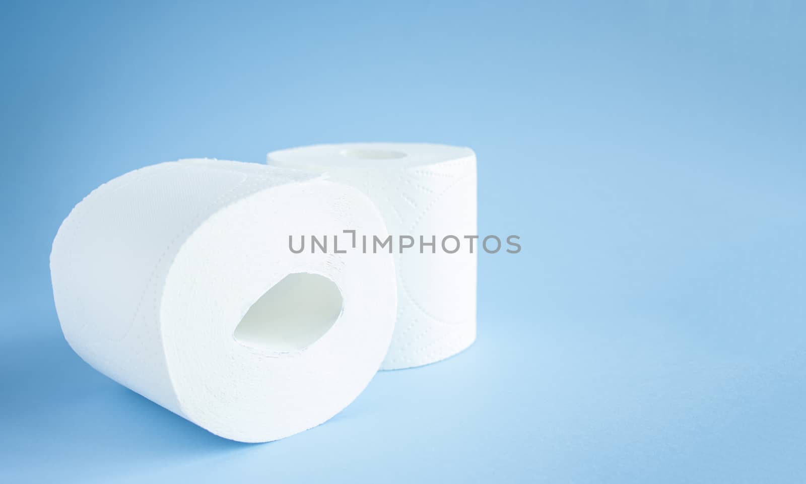 two Toilet paper roll on a blue background top view. Toilet paper purchase due to kronavirus concept. Personal hygiene and stopping the spread of the virus. Cleanliness, Hygiene, Sterility copy space