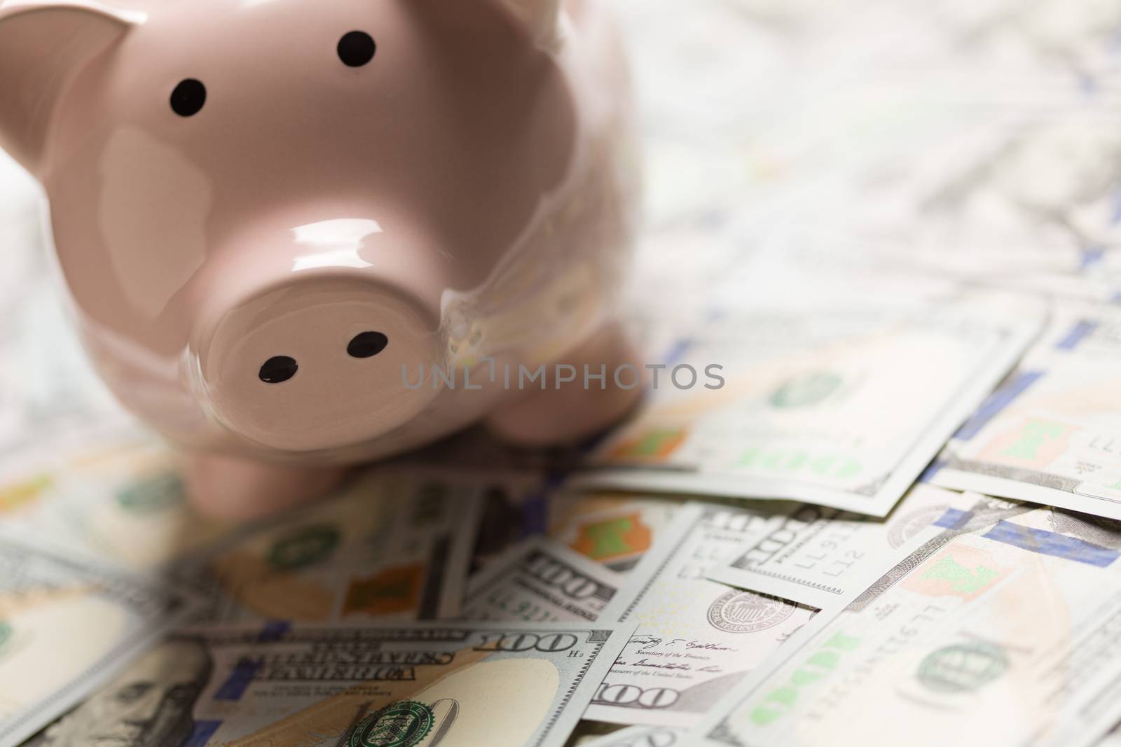 Piggy Bank On Pile on United States One Hundred Dollar Bills.