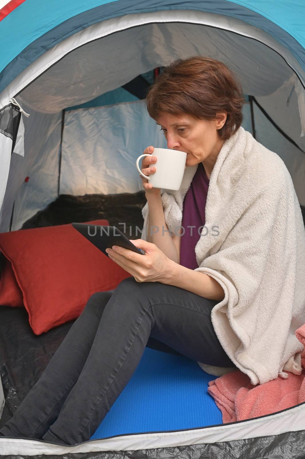 Woman sit inside a tent enjoying a cup of tea by mady70