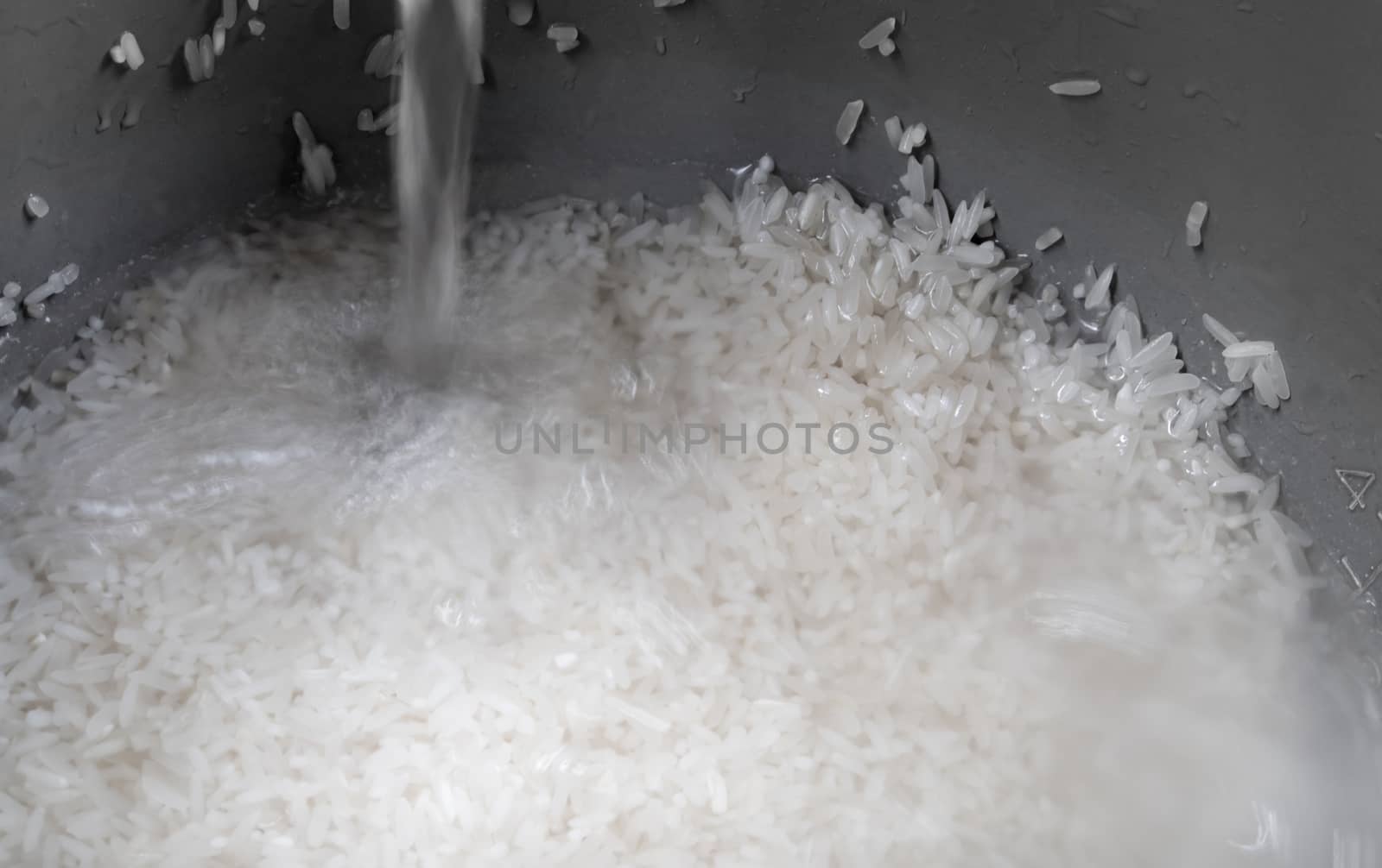 Rice prepared for cooking in an electric rice cooker by Satakorn