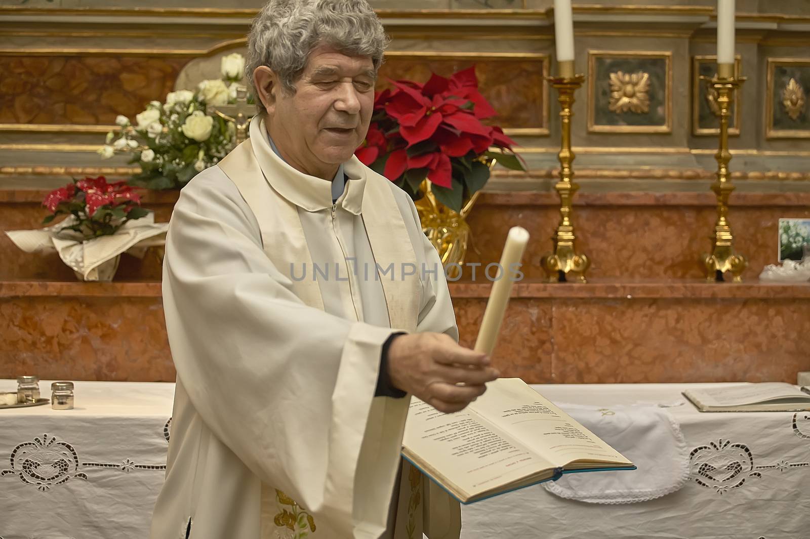 Priest gives the candle to baptism, symbol of a part of the Christian ceremony
