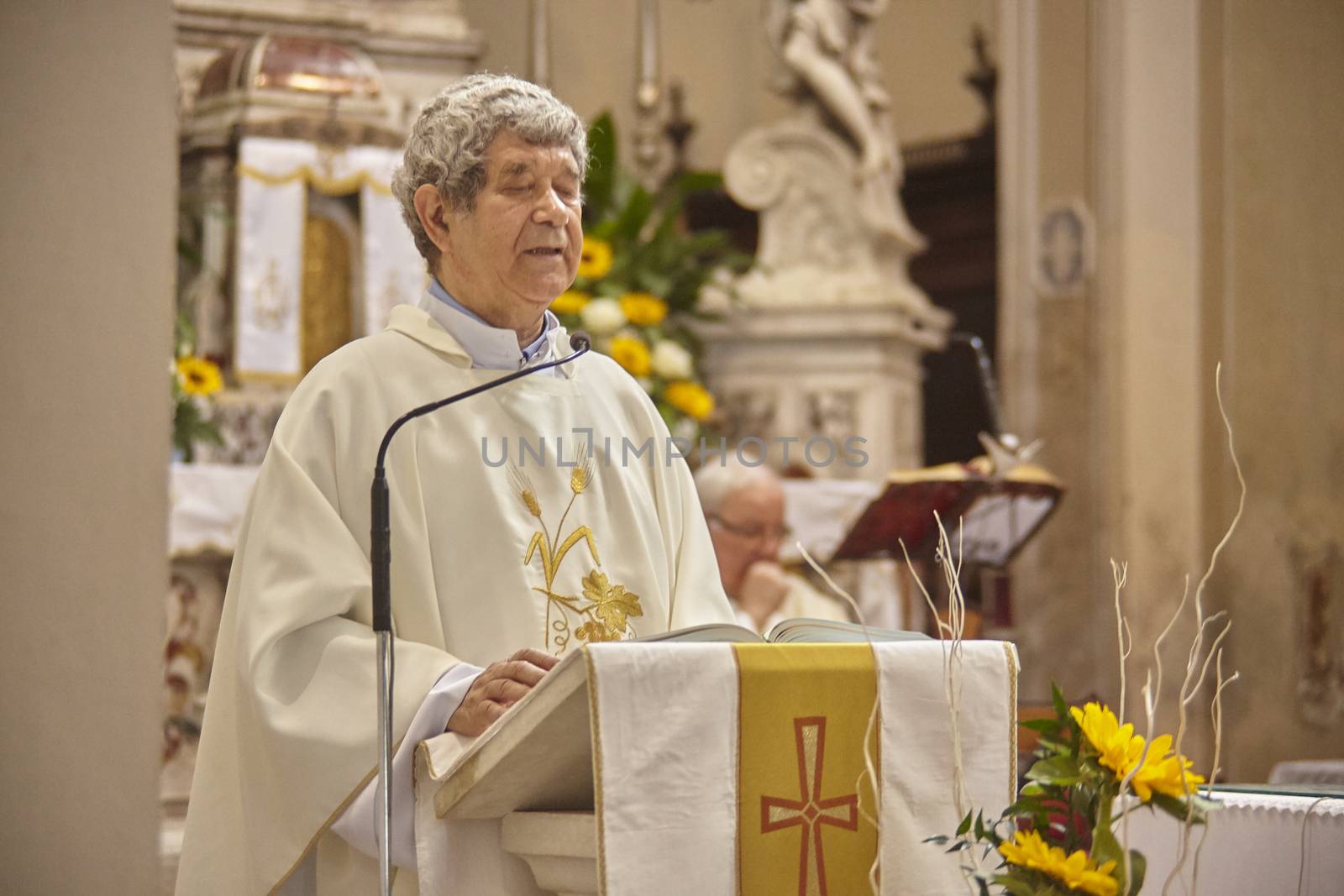 Priest celebrates the liturgy in a Catholic church in Italy