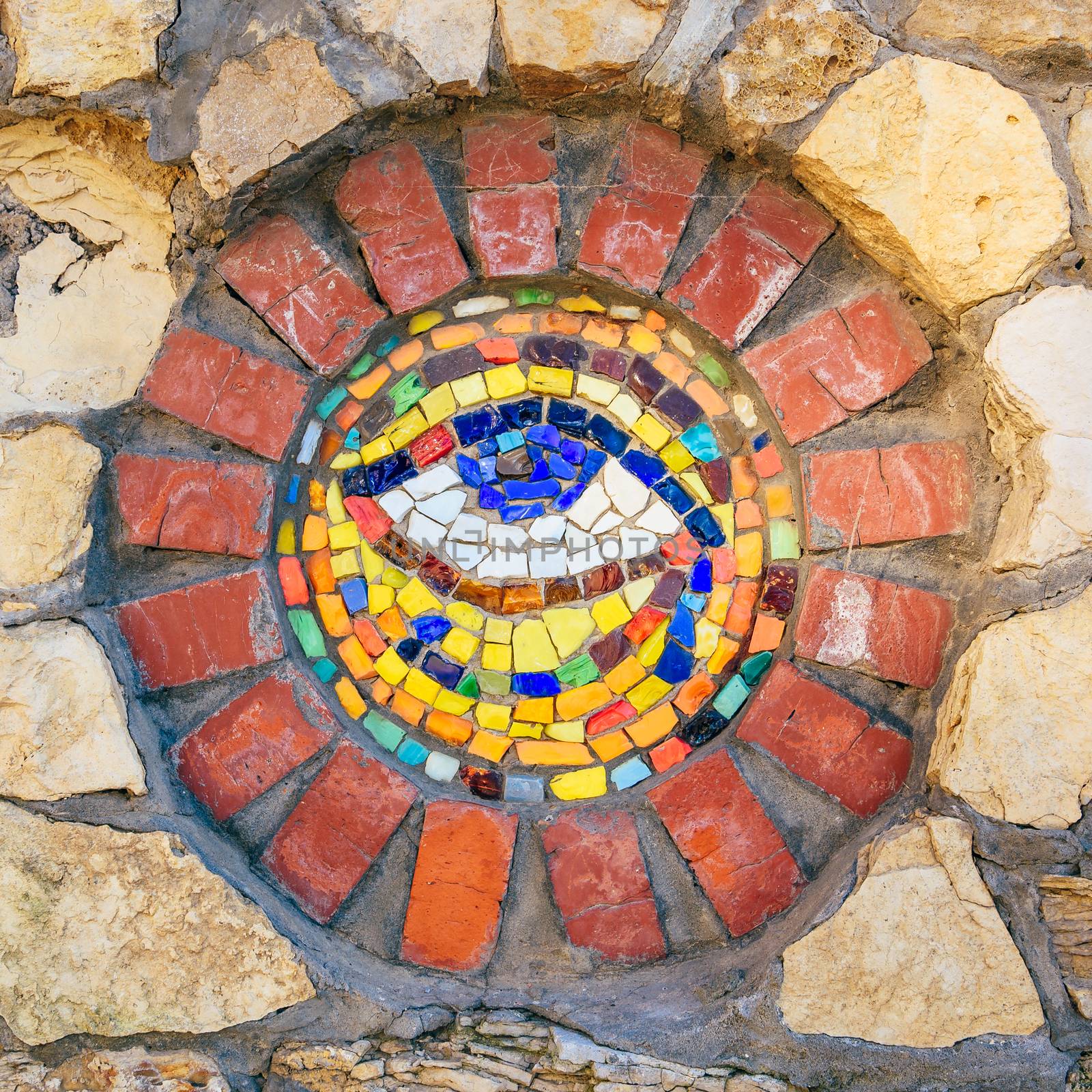 Circular mosaic symbol Eye of Horus on stone wall.