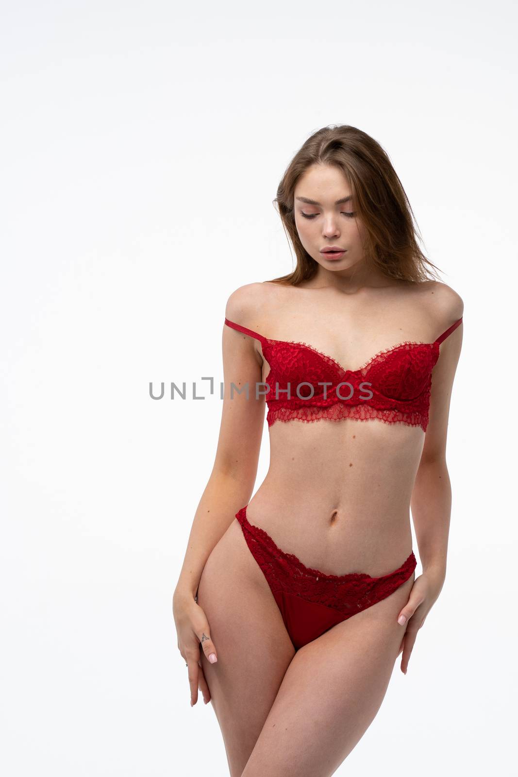 young beautiful girl posing in studio to red lingerie