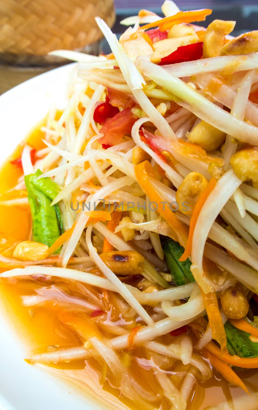 Spicy Thai Papaya Salad in the white plate by Satakorn