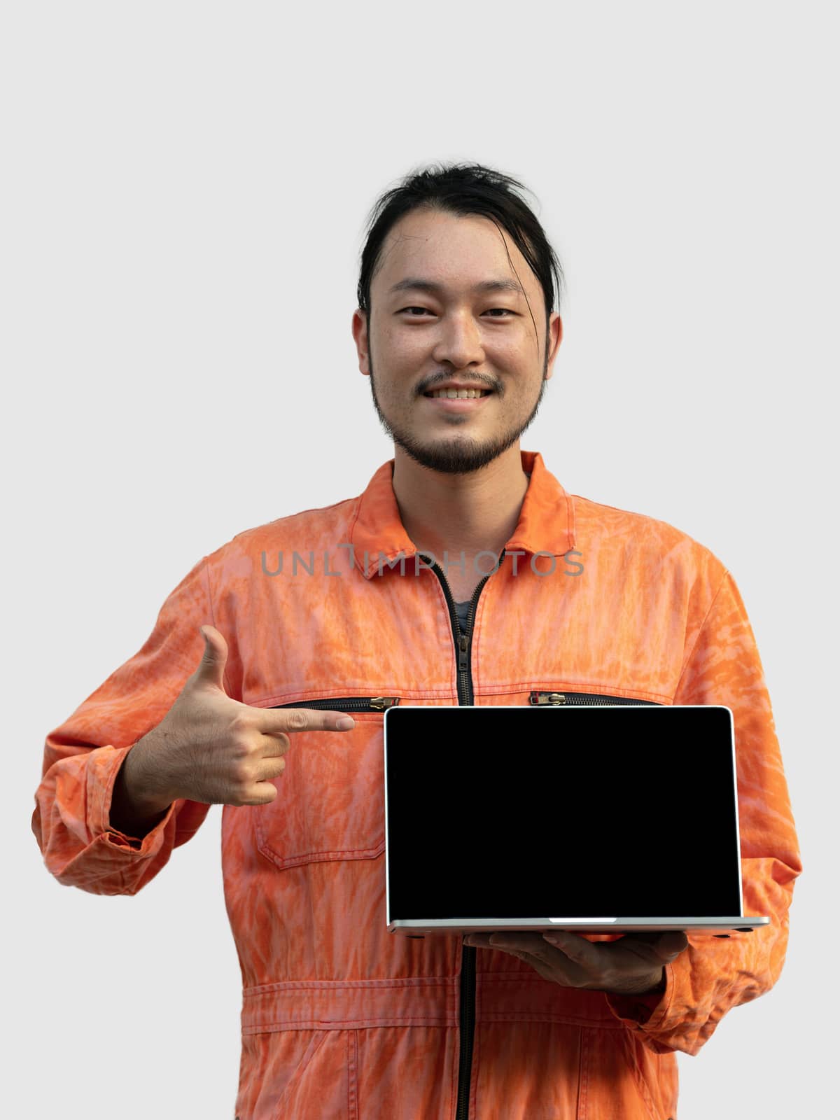 The chief mechanic in an orange uniform holding blank screen laptop. Standing with his finger point to computer. Portrait with studio light.