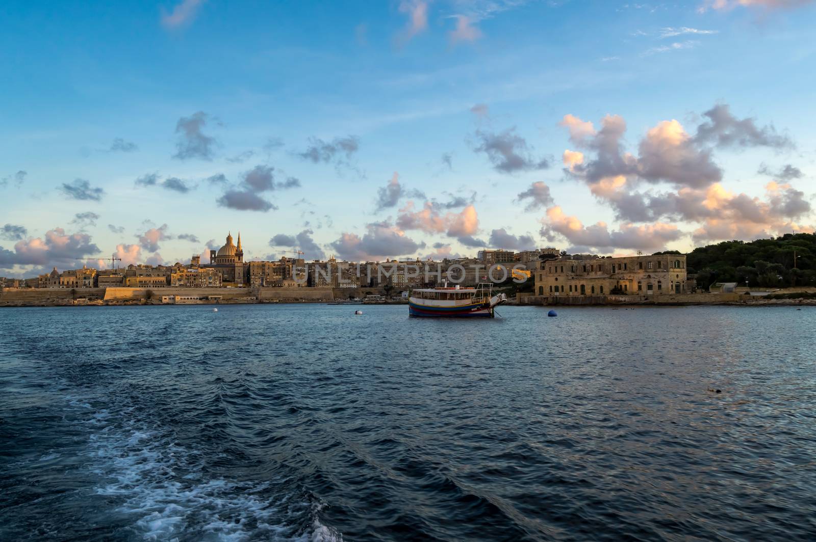 Panoramic view of Valletta Skyline at beautiful sunset from Sliema with churches of Our Lady of Mount Carmel and St. Paul's Anglican Pro-Cathedral, Valletta, Capital city of Malta