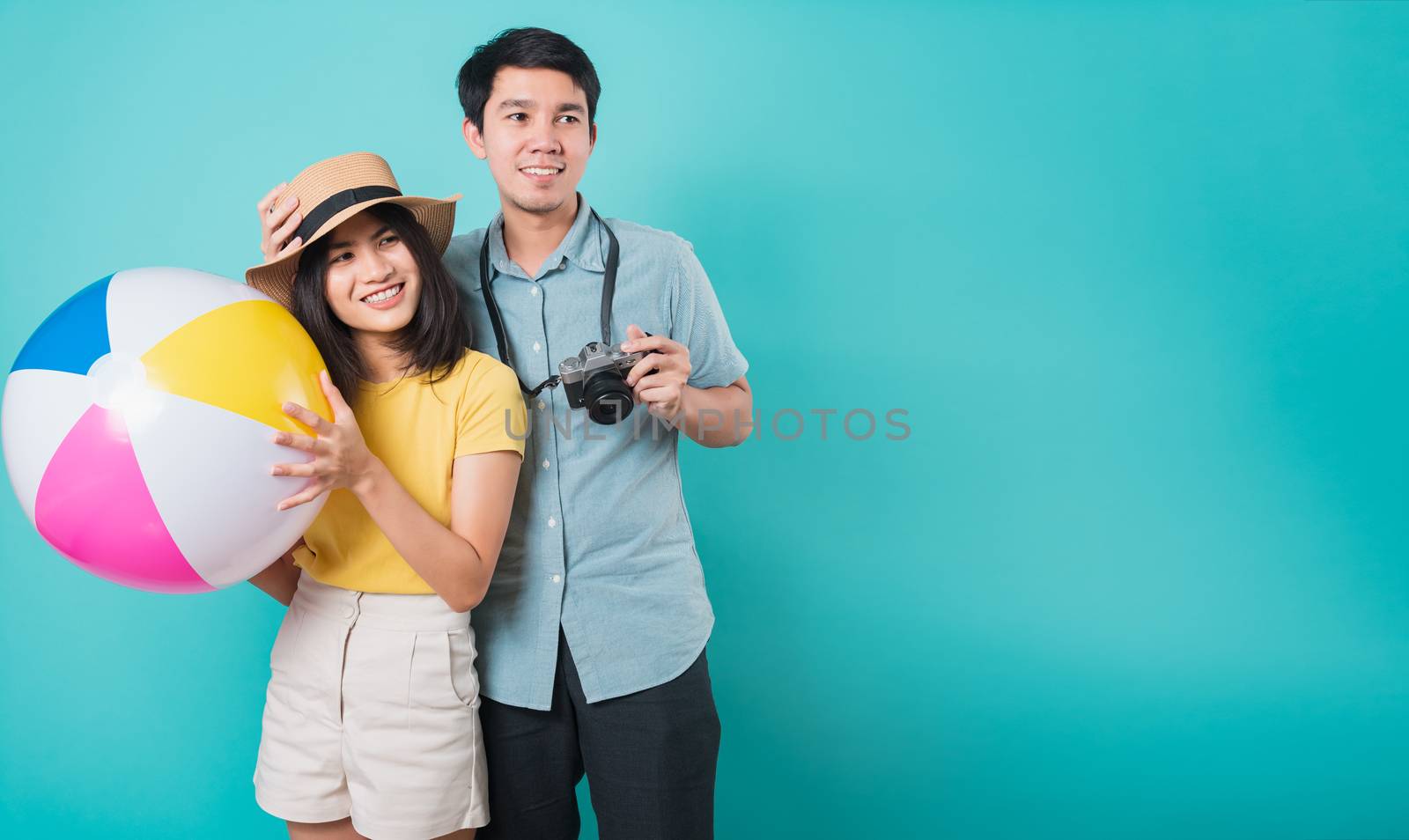 Happy Asian young beautiful woman handsome man couple in summer in holiday travel beach accessories ball and camera isolated on blue background with copy space for text