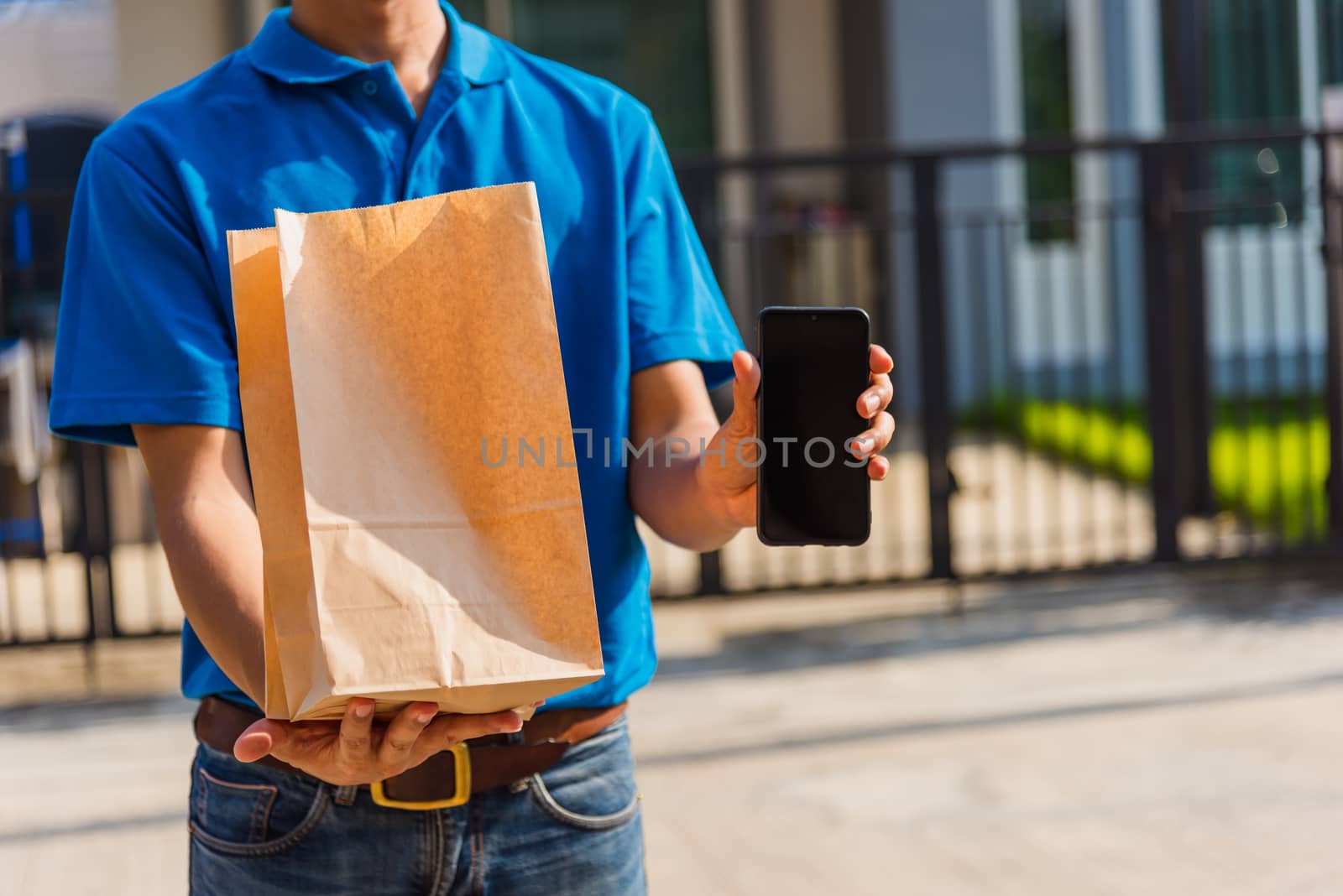 Asian Young delivery man courier online with food order takeaway paper bag containers he protective face mask, service customer in front house under curfew quarantine pandemic coronavirus COVID-19