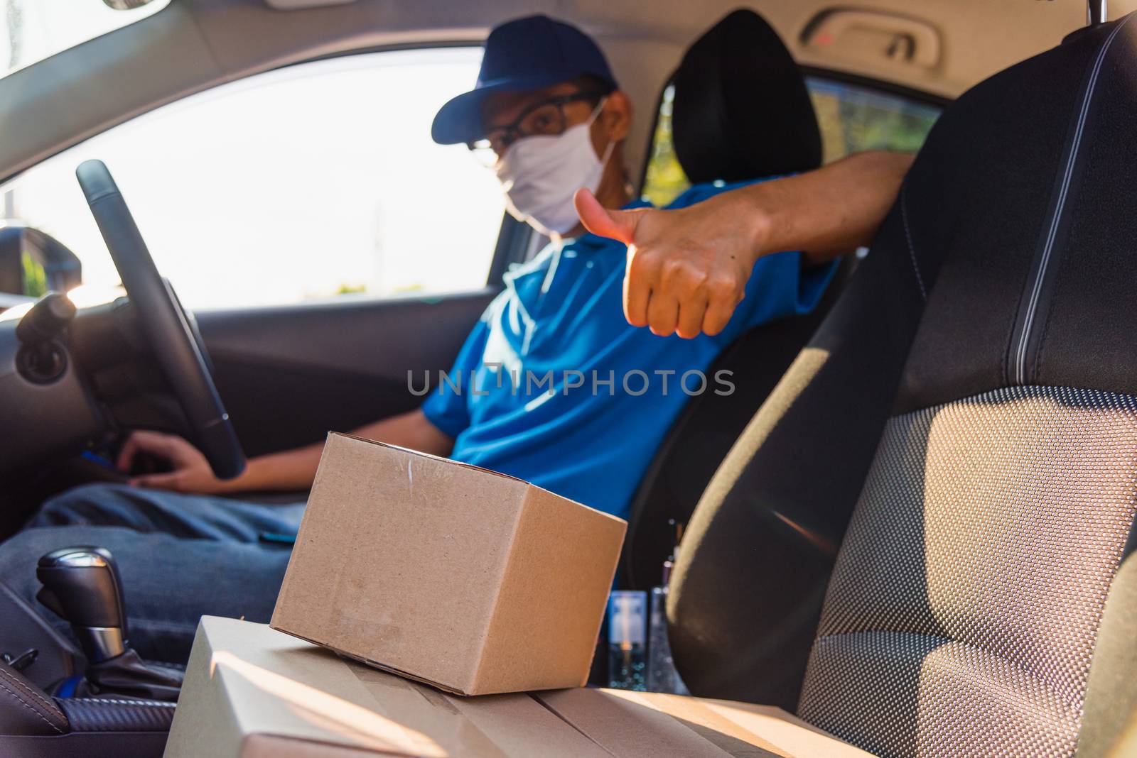 delivery man courier online with boxes with uniform sitting in d by Sorapop