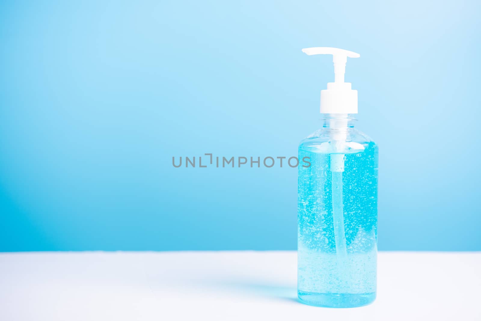 Plastic dispenser sanitizer alcohol gel pump bottle for washing hand hygiene prevention of coronavirus virus studio shot on blue background
