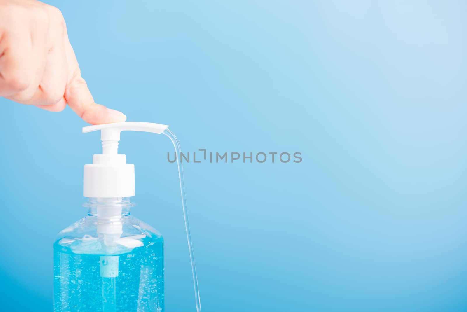 Close up Asian young woman applying press dispenser sanitizer alcohol gel pump to hand wash cleaning, hygiene prevention COVID-19 or coronavirus protection concept, isolated on blue background