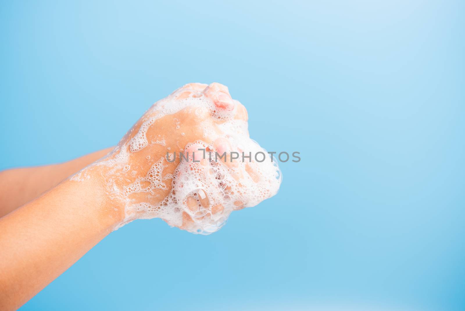 Closeup body care Asian young woman washing hands with soap have foam, hygiene prevention COVID-19 or coronavirus protection concept, isolated on blue background