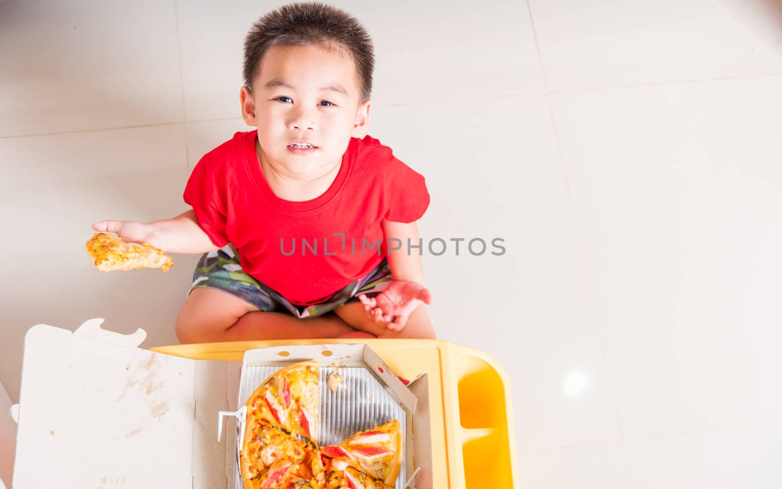 Top view of Cute Little Child eating Delivery Pizza by Sorapop