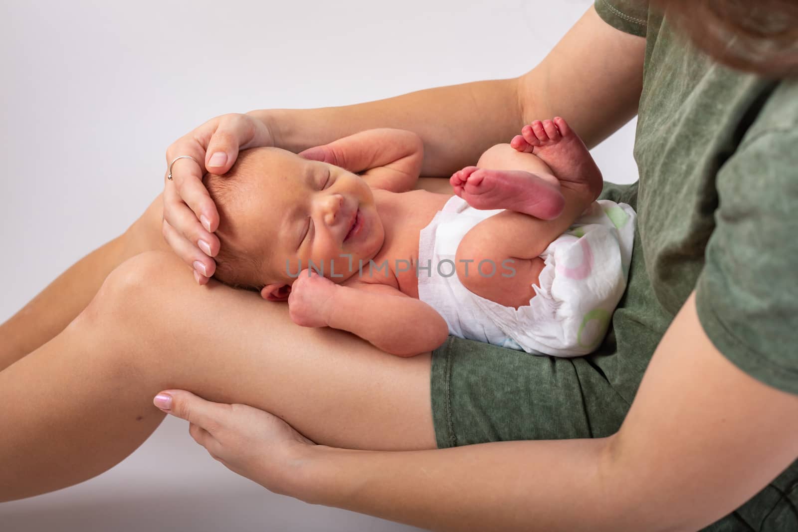 Beautiful new born baby resting on mom's hands.