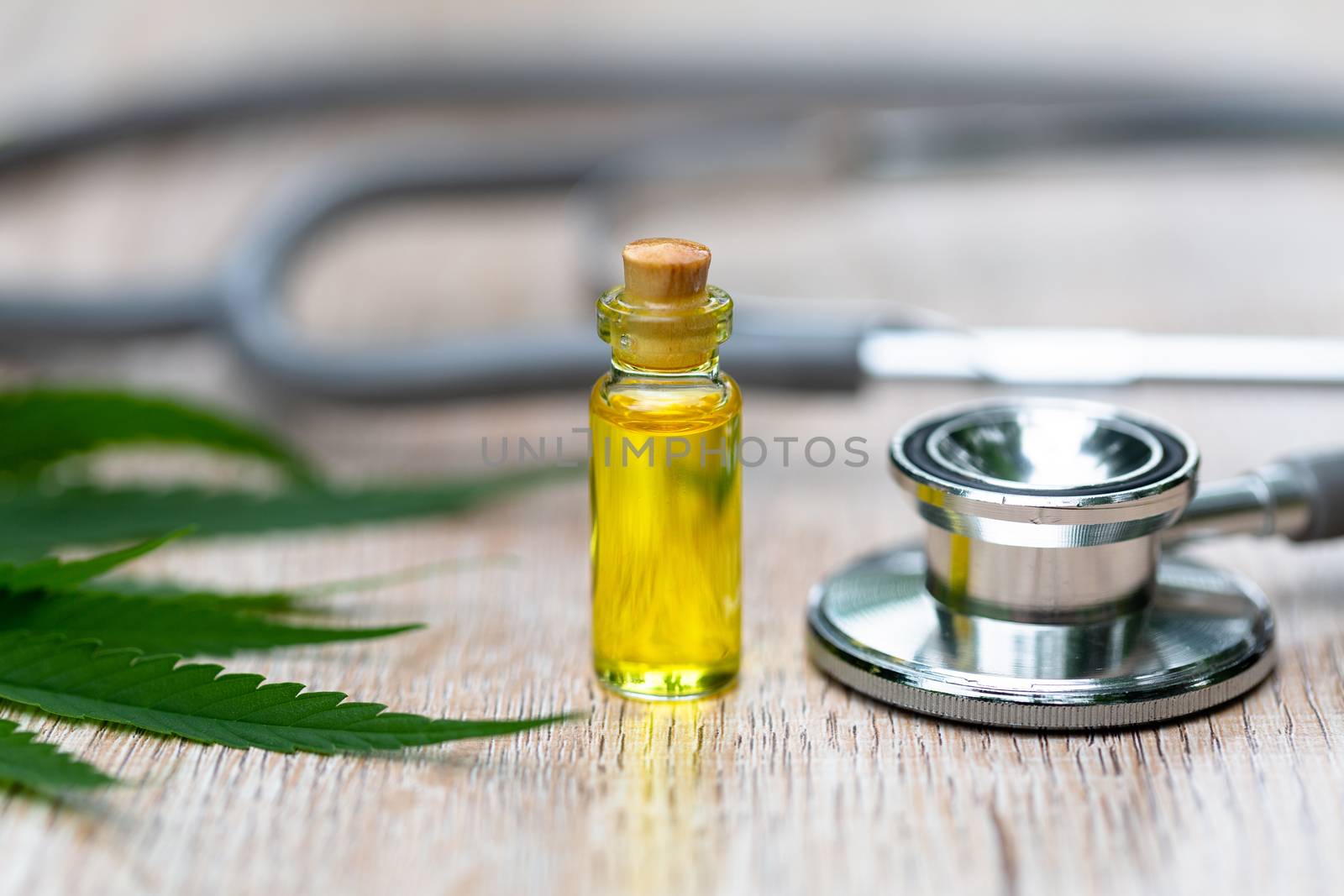 Hemp oil bottle Medical stethoscope And the leaves of cannabis Placed on the table. Concepts of alternative medicine, treatment of diseases. The invention of natural herbs as a treatment medicine.