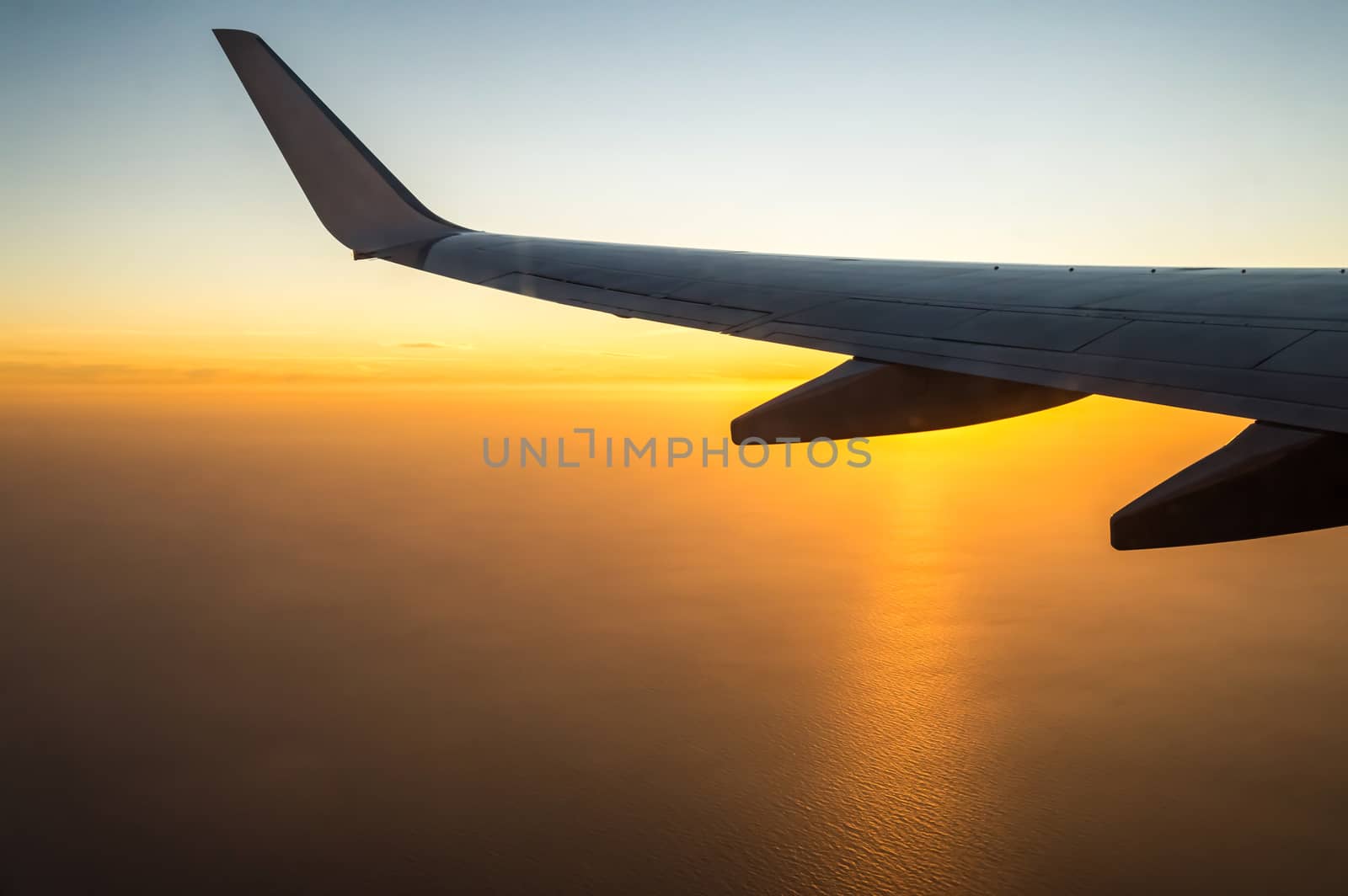 Beautiful sunset, sky on top view, airplane flying view from inside the window of travel planes.