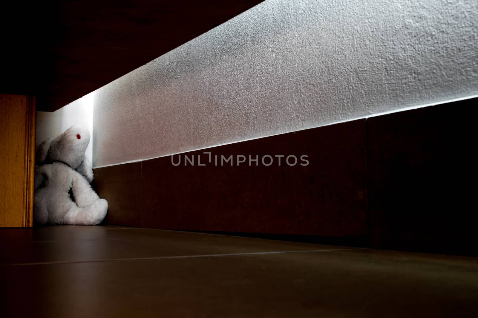 Neglected doll Fall in the dark corner under the bed