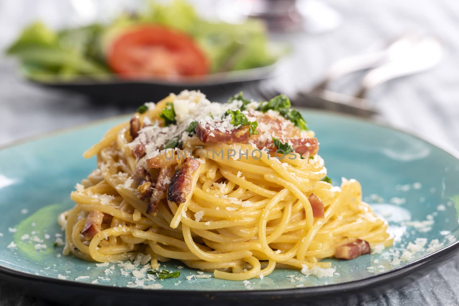 spaghetti carbonara on a blue plate