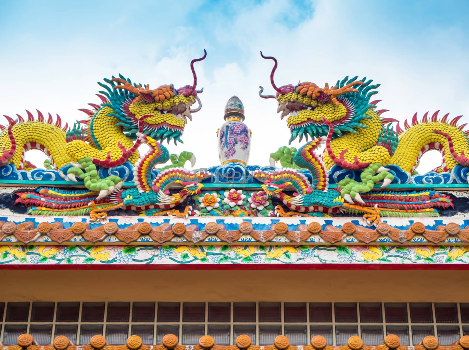 Colorful twin chinese dragon statues adorned the rooftops of pavilions in Chinese religious venues