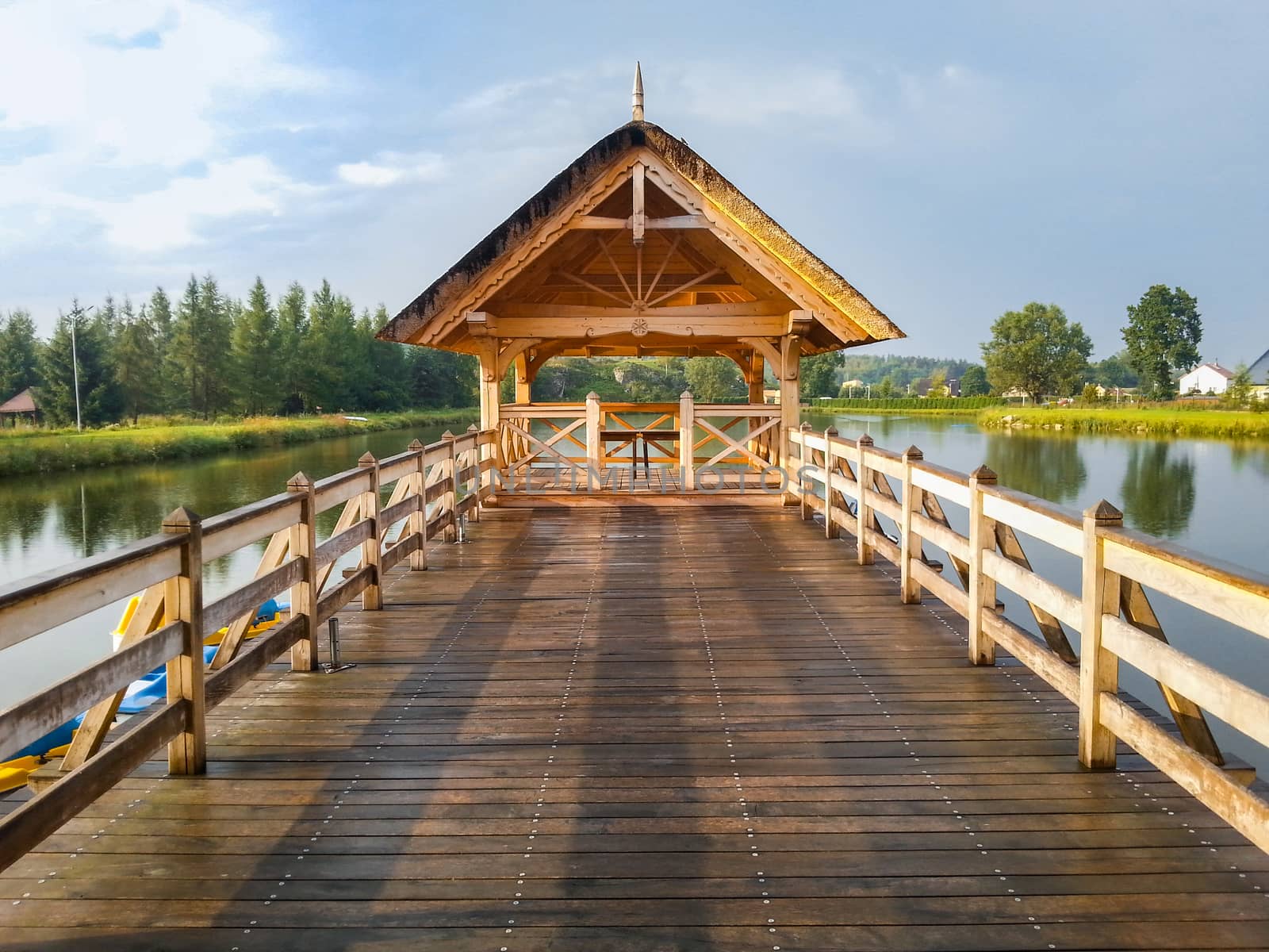 Wooden Bower on lake and bridge at rainy day by Wierzchu