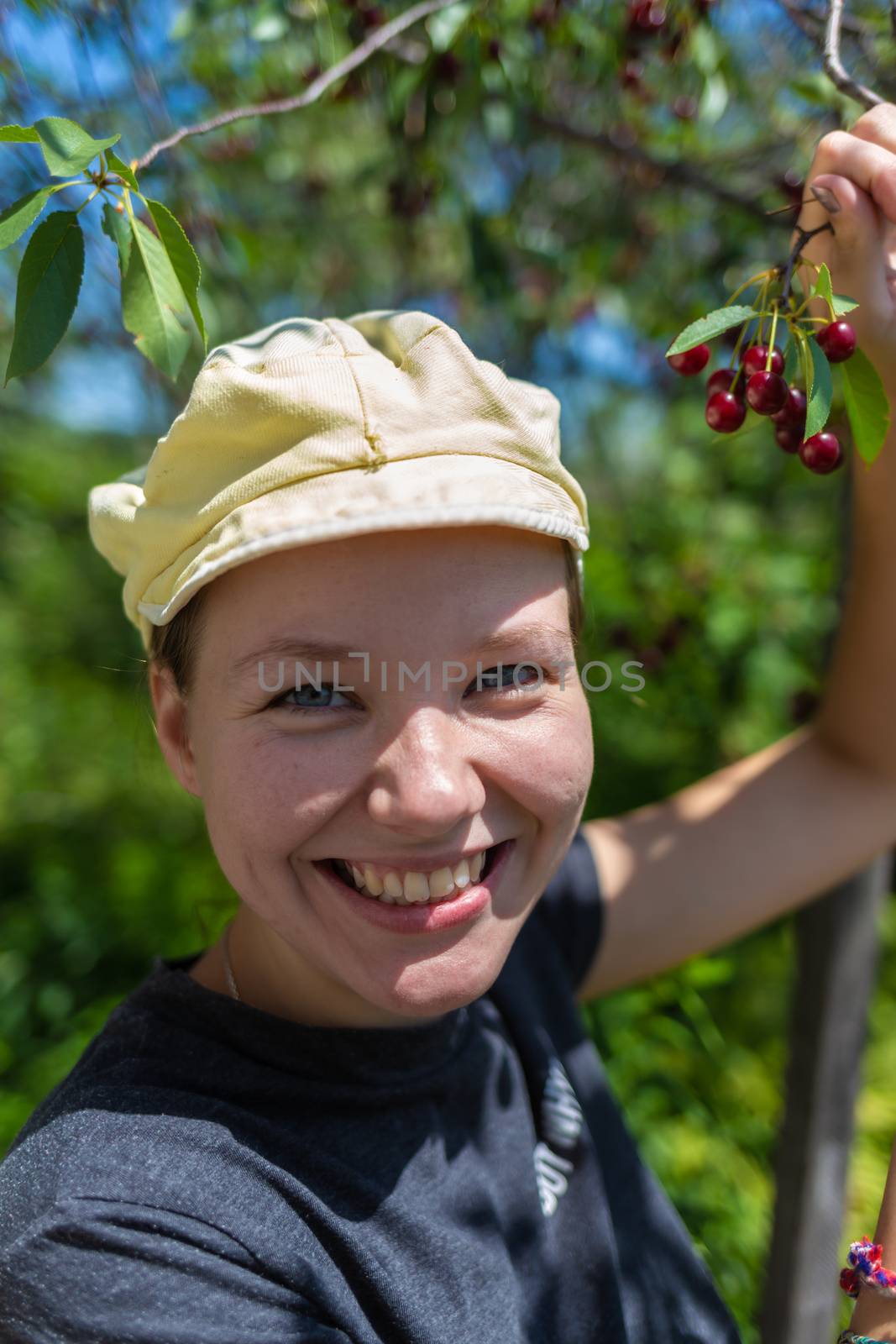 Young, beautiful girl in the bush of viburnum and apple tree