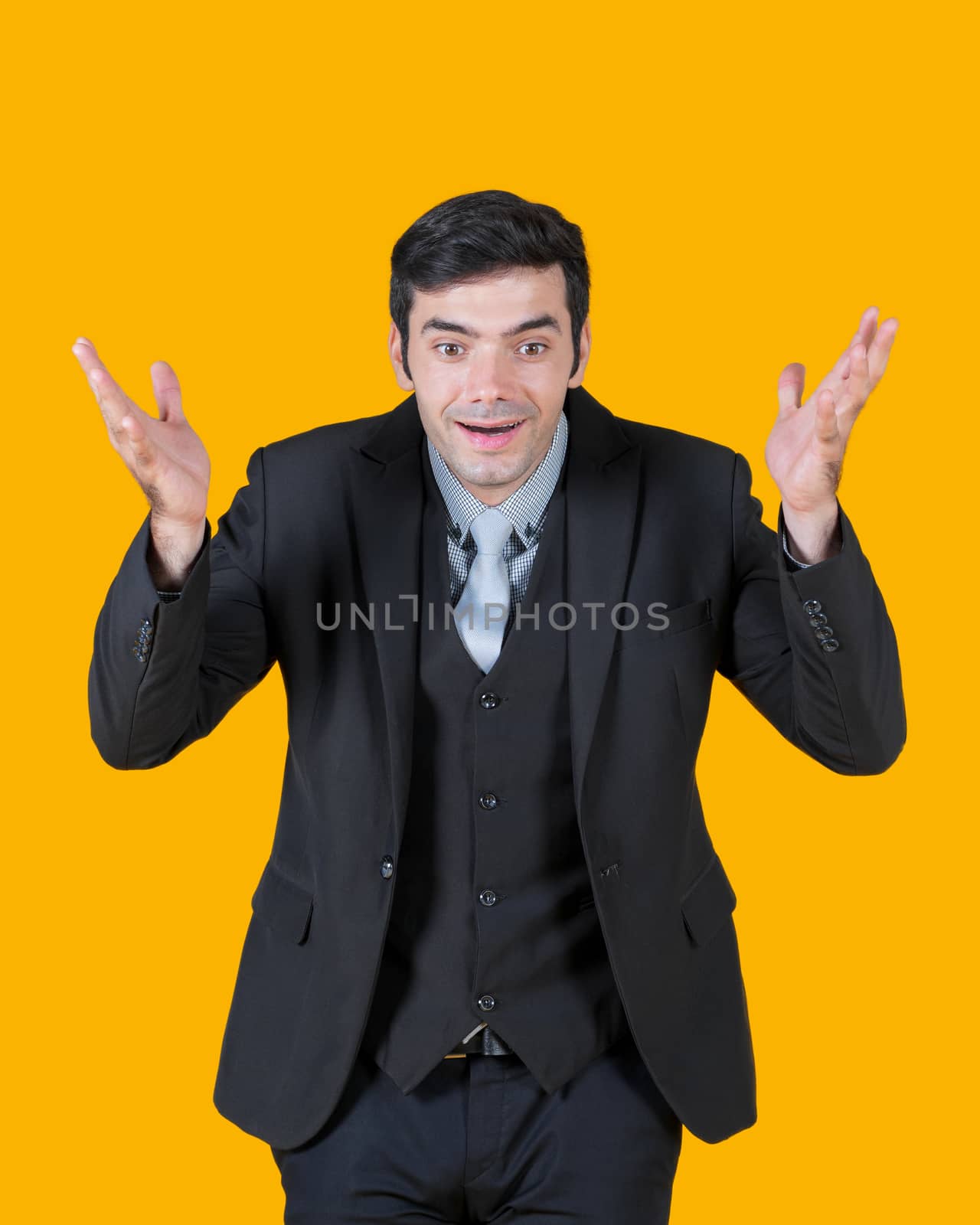 A young businessman in a gray shirt and a black suit, raise both hands up with a surprised expression. The concept of investing in good business.