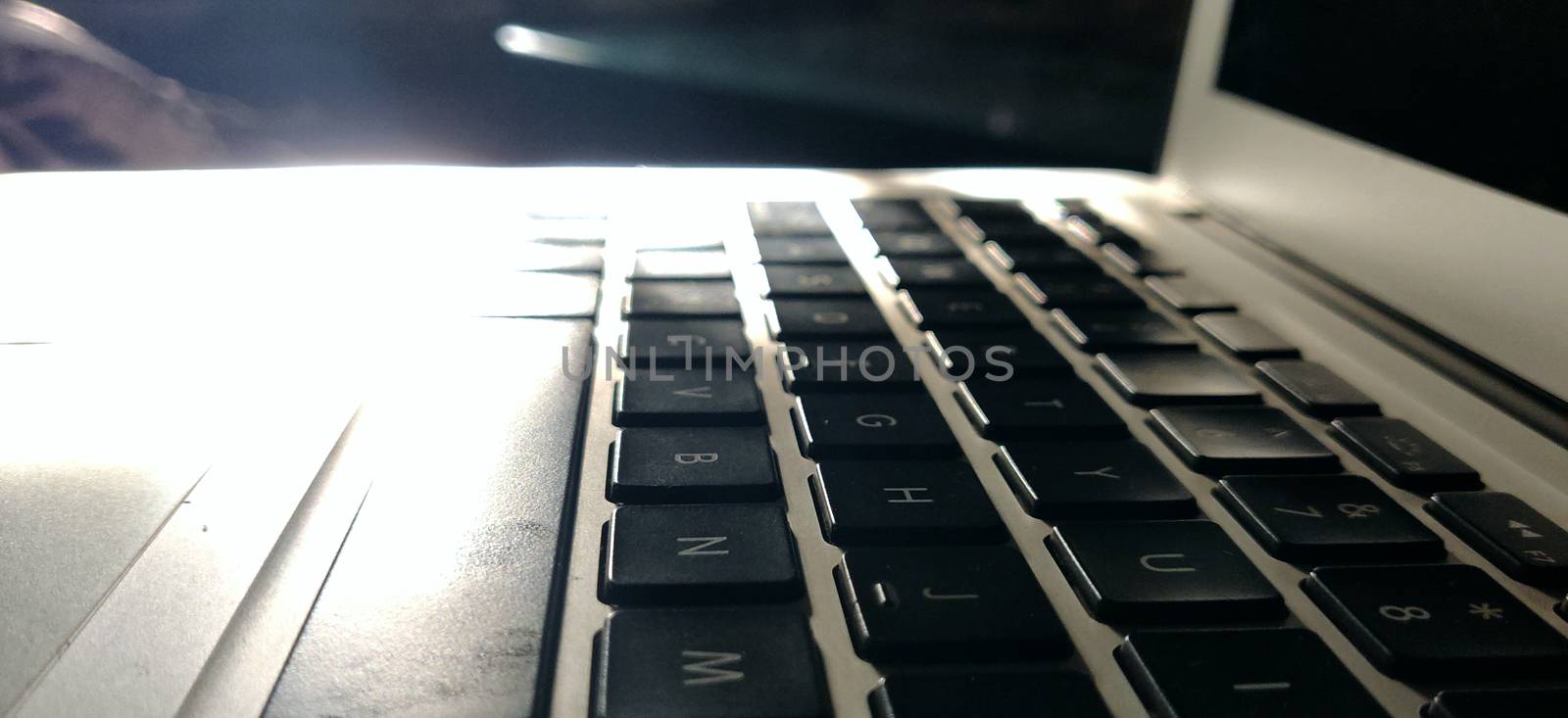 Macro shot of laptop keypads basking in the pure light of the morning sun.