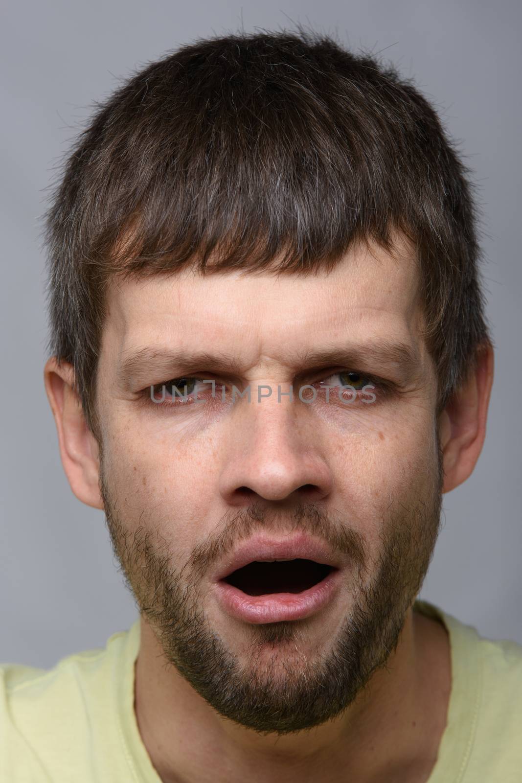 Closeup portrait of a tired yawning man of European appearance