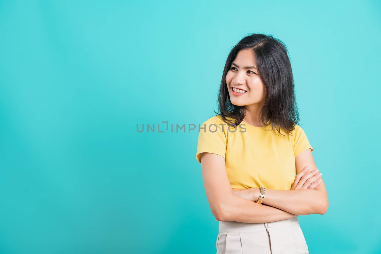 young woman smiling standing cross arm with looking side away by Sorapop