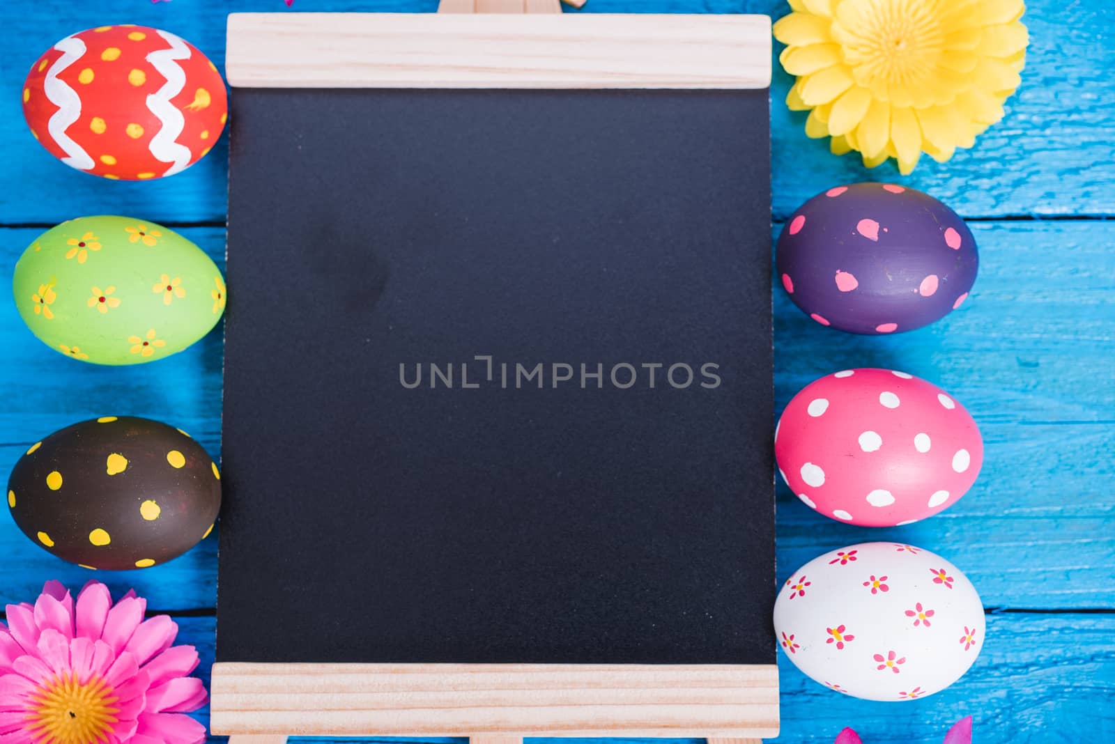Easter eggs top view on blue wooden background and have board work space board for use