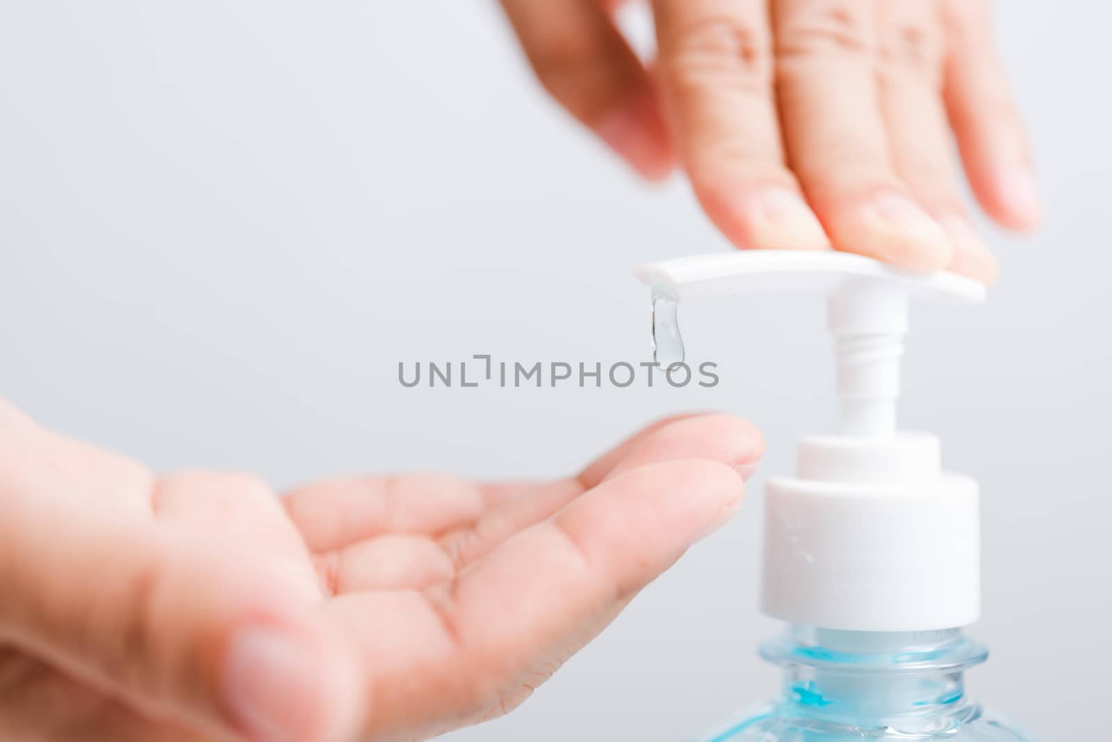 Close up Asian young woman applying press dispenser sanitizer alcohol gel pump to hand wash cleaning, hygiene prevention COVID-19 or coronavirus protection concept, isolated on white background