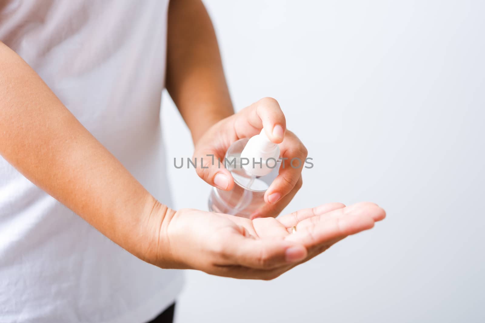 Closeup Hand Asian young woman applying spray pump dispenser sanitizer alcohol on hand wash cleaning, hygiene prevention COVID-19 or coronavirus protection concept, isolated on white background