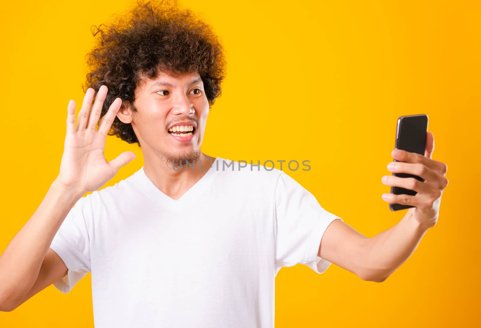 Portrait asian handsome man curly hair taking selfie with mobile by Sorapop