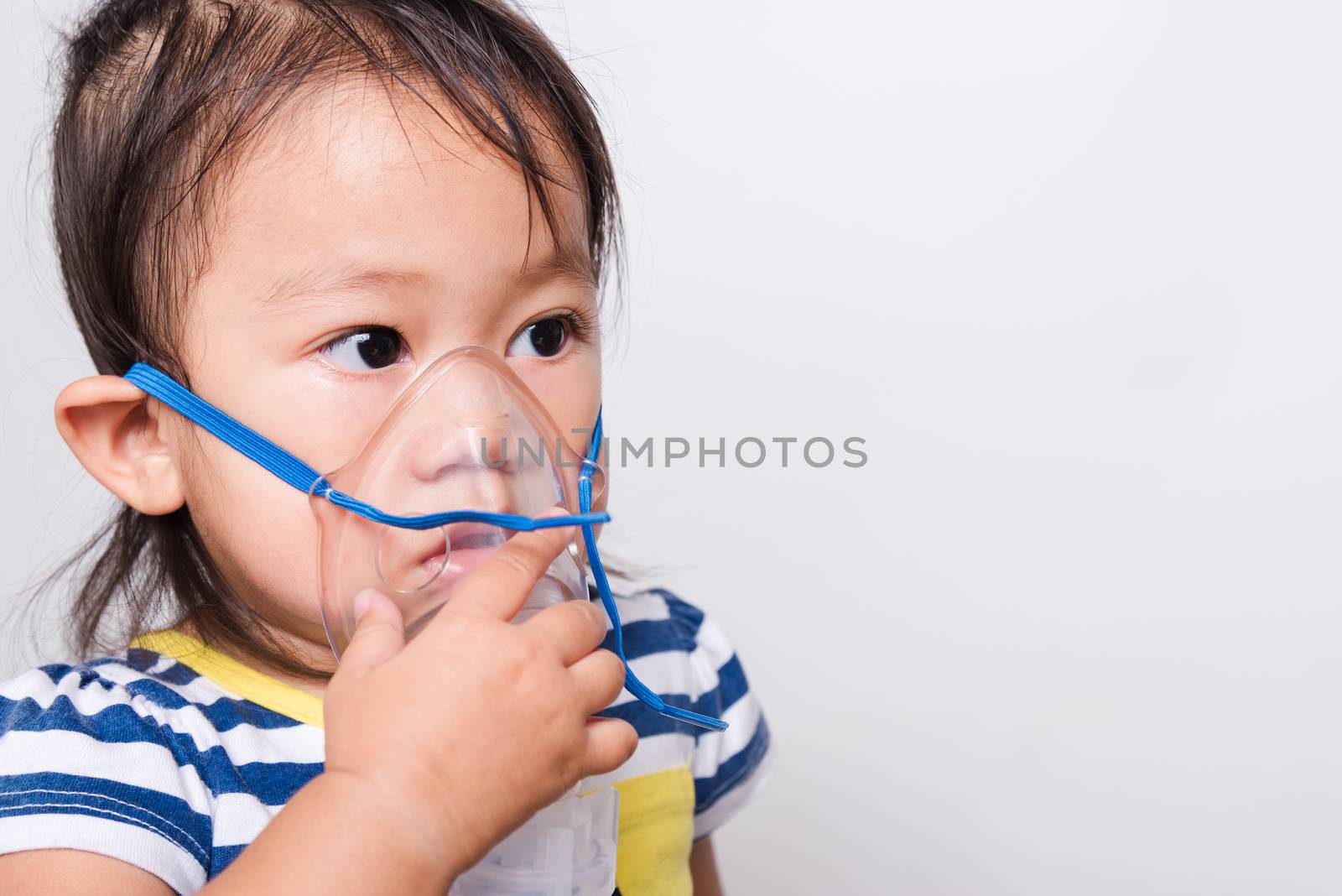 Closeup Asian face, Little baby girl sick her using steam inhaler nebulizer mask inhalation oneself on white background with copy space, health medical care