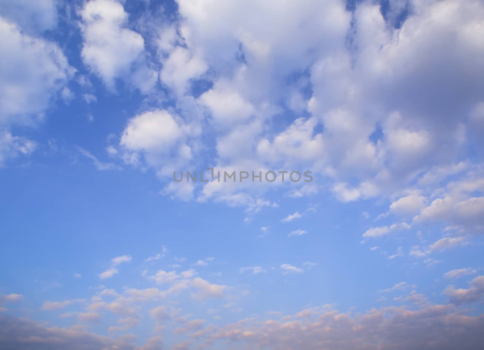 White fluffy clouds in the blue sky with morning light from the sunrise