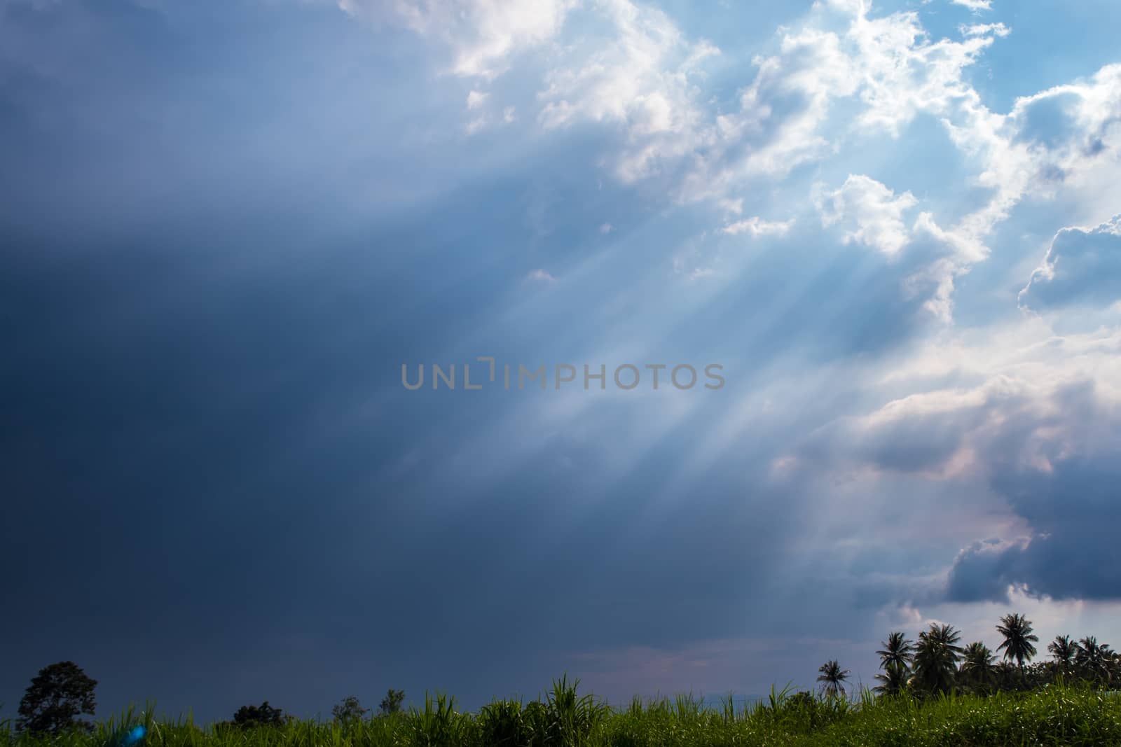 Beam of Sunlight behind dark clouds by Satakorn