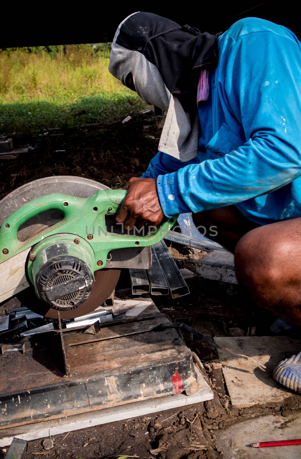 Worker cutting steel with a cutting machine by Satakorn