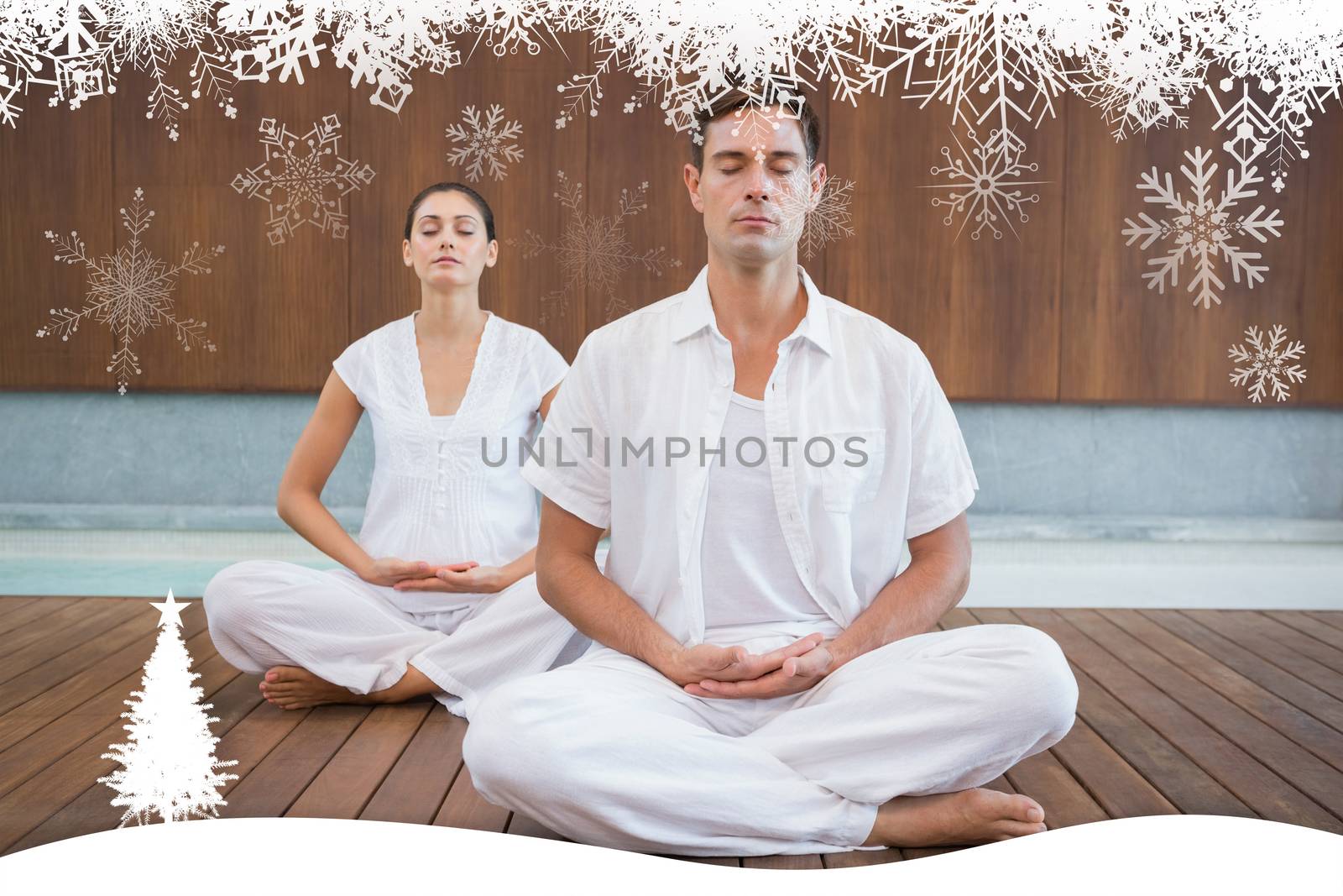 Peaceful couple in white sitting in lotus pose together against fir tree forest and snowflakes