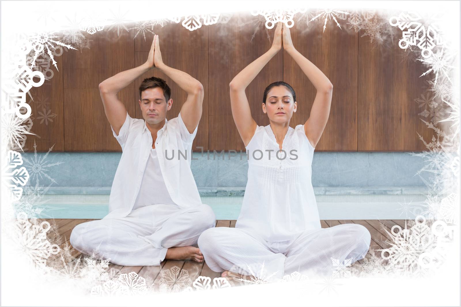 Attractive couple in white sitting in lotus pose with hands together against frost frame