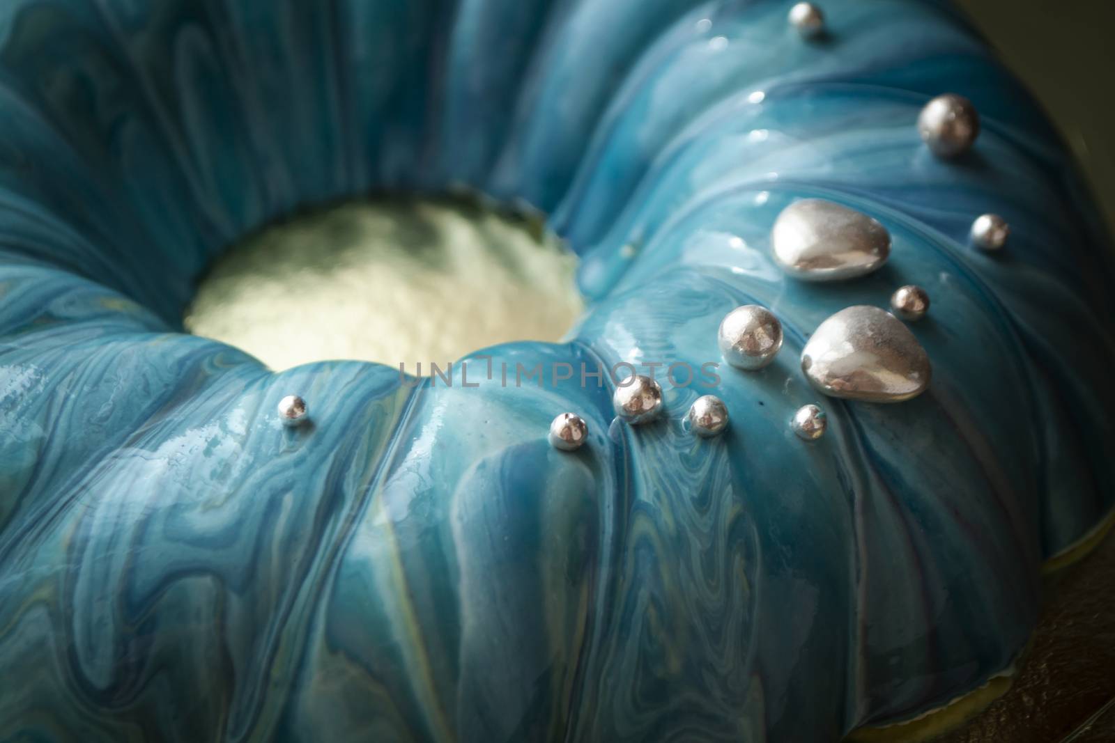 Trendy mousse cake with blue and turquoise mirror glaze. Close up