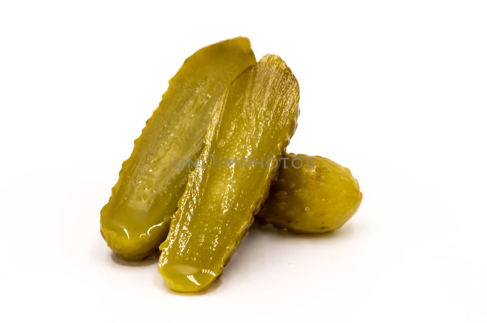 Closeup pickled cucumber cut in half on a suit isolated on white background