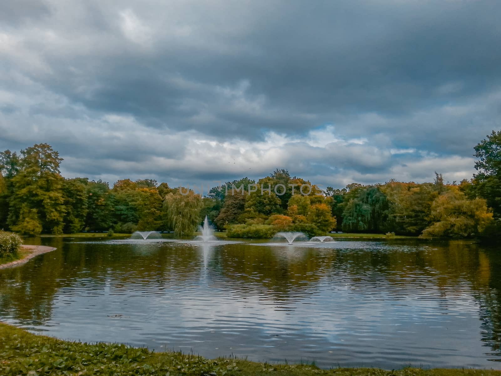 Fountains on great lake in south park in Wroclaw at colorful autumn