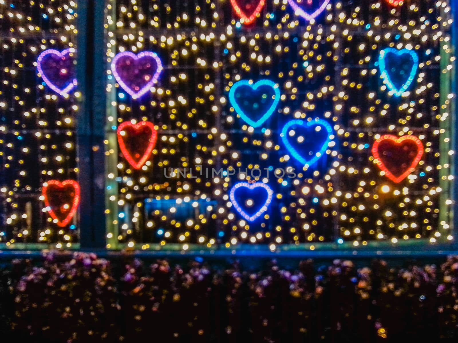 Colorful love decorations out of focus at night on bridge in Wroclaw