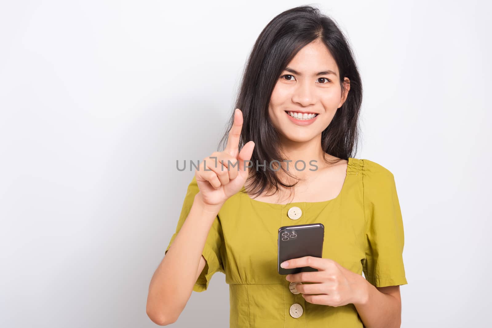 young woman standing smile holding using mobile smart phone by Sorapop