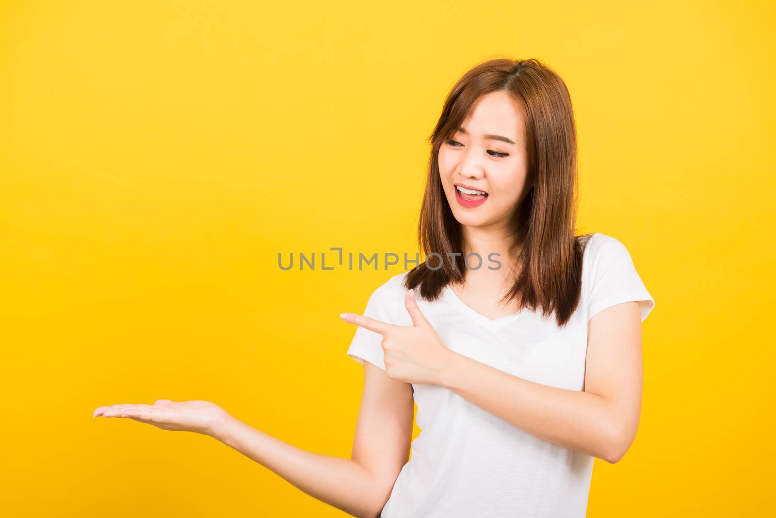 woman teen standing holding something on palm and point away sid by Sorapop