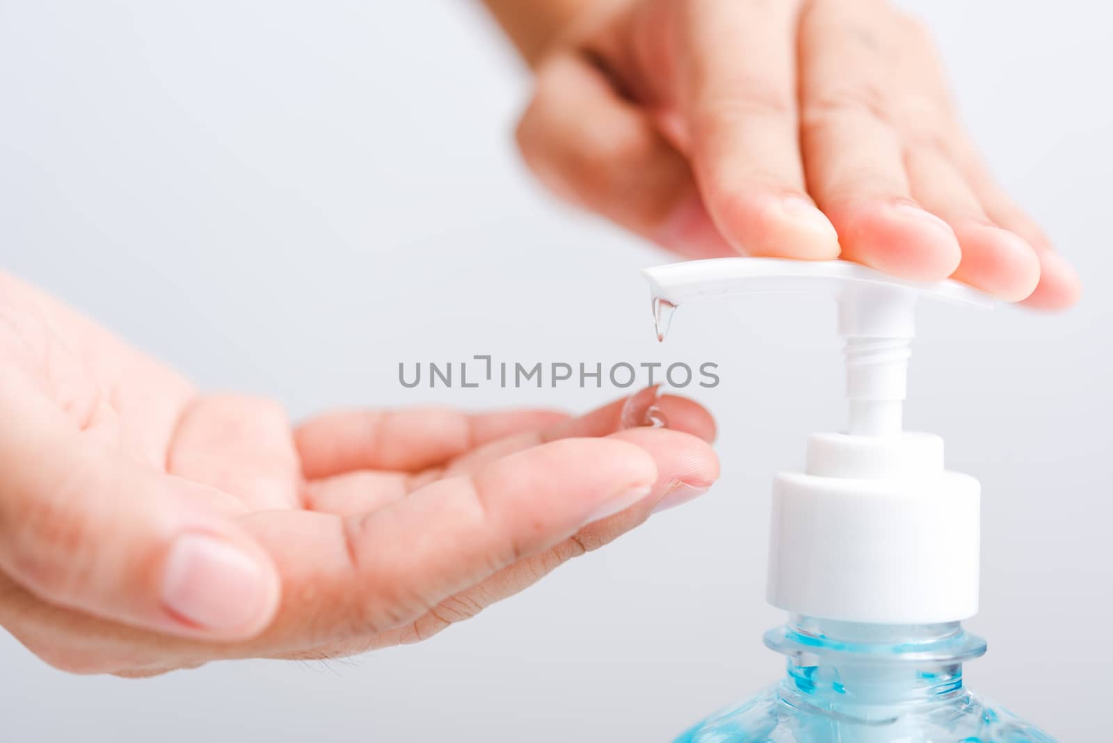 Close up Asian young woman applying press dispenser sanitizer alcohol gel pump to hand wash cleaning, hygiene prevention COVID-19 or coronavirus protection concept, isolated on white background