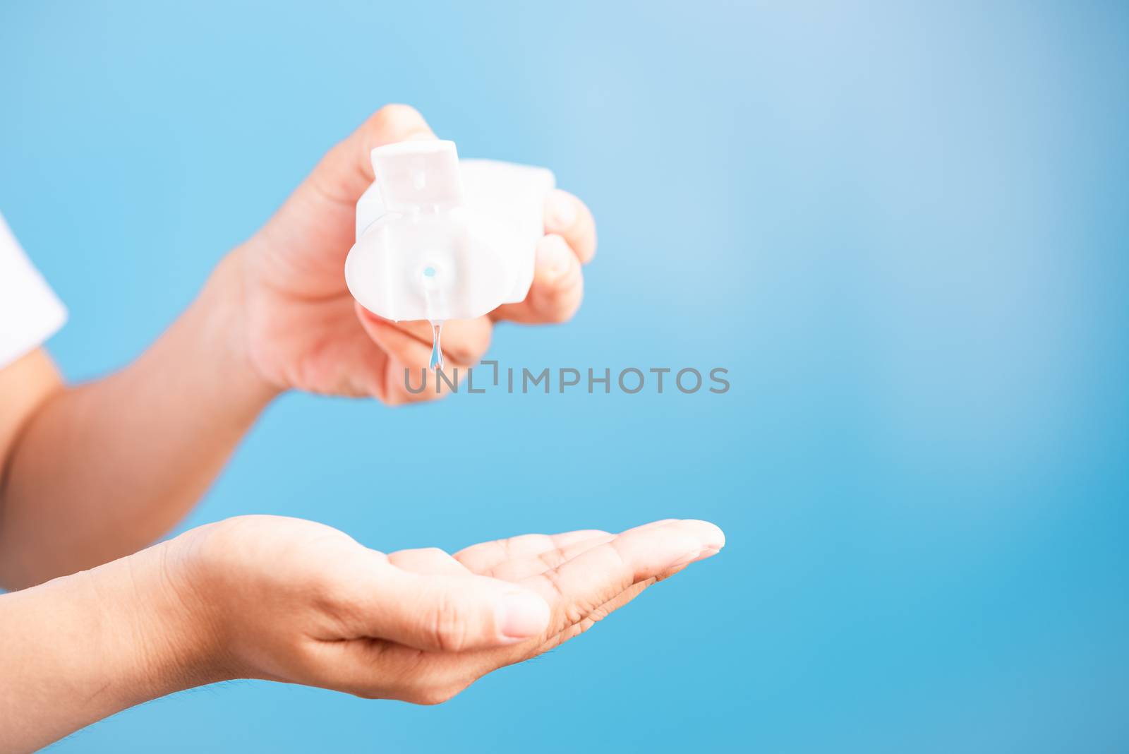 young woman applying drop dispenser sanitizer alcohol gel on han by Sorapop