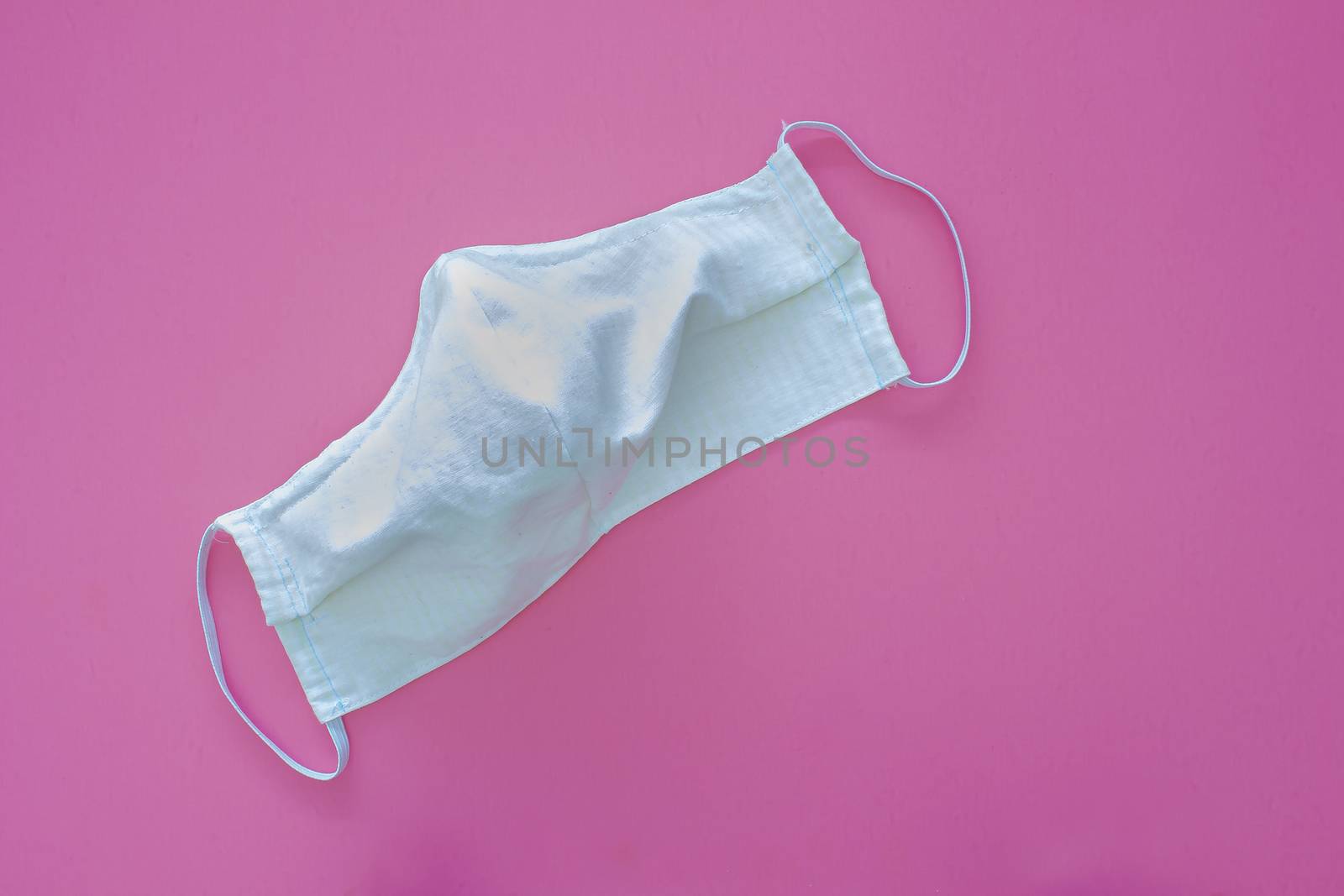 White homemade face mask for adults on a pink background by oasisamuel